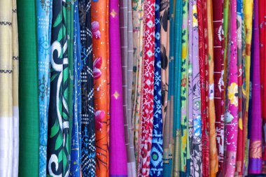 Batik, baskı ve nakış da dahil olmak üzere renkli kadınların kumaşları, Kishoreganj 'da uluslararası bir ticaret fuarında satışta. Kadın kumaşlarının ve kıyafetlerinin arka planı.