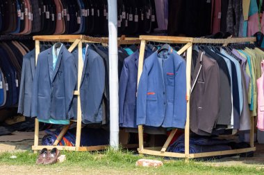 Birçok lüks ve profesyonel erkek ceketi, 23 Şubat 2025 'te Bangladeş' in Kishoreganj kentindeki uluslararası ticaret fuarında satılık bir askıda asılı duruyor..