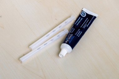 Tahta bir yüzey üzerinde aplikatörlerle tüp içinde döllenme öncesi üreme yağı. Gebe kalmaya çalışan çiftler için ideal ve hamilelik de dahil olmak üzere cinsel deneyimleri geliştirmek için kayganlaştırıcı bir jel..