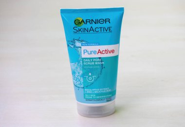 GARNIER Skinactive Daily Pore yüz yıkama tüpü. Tahta bir yüzey üzerinde. Yağlı cildin kusurlara yatkın olması için. Dermatolojik olarak test edilmiş. Kozmetik ürünü.