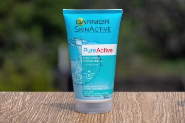Garnier SkinActive Daily Pore yüz yıkama tüpü, doğal ahşap yüzey, yemyeşil zemin. Derin temizleme, yağ ve kir temizleme için cilt bakımı ürünü.