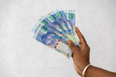 Güney Afrika 100 Rand banknotlarını tutan bir kadın. Güney Afrika parası 100 rand..