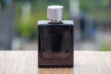 Yardley London İngiliz Blazer Black Eau de Parfum şişe ahşap, arka manzara, bulanık doğa arka planı.