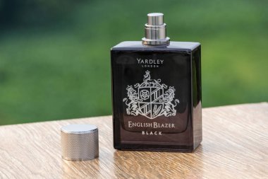 Yardley London İngiliz Blazer Black Eau de Parfum, kapak açık, tahtada bulanık tabiat ile.