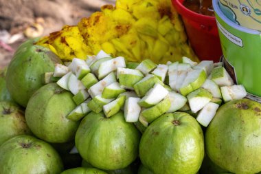 Taze guava meyveleri ve dilimlenmiş guava Bangladeş 'te bir sokak meyve dükkanında. Sokak satıcıları Guava Vorta, Peyara Makha, Masala Guava satıyor..