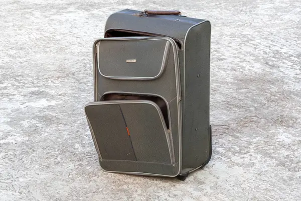 Beton zeminde eski bir tramvay çantası. Yıllardır kullanılıyor, şimdi yırtık ve hasarlı bir fermuar zinciri var..