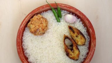 Geleneksel Bengali Yeni Yılı Panta Ilish (Pohela Boishakh). Pirinç, aloo bhorta, acı biber, soğan ve kil tabakta kızarmış Hilsa balığı. Bangladeş ve Hindistan 'da popülerdir..