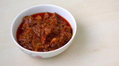 Ahşap yüzeyde beyaz kâse içinde nefis bir biftek bhuna köri. Lezzetli, lezzetli, baharatlı ve popüler bir Bengali (Bangladeş) yemeği..