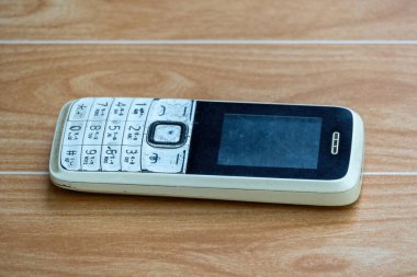 Kullanılmış ahşap düğmeli telefon. Bengali dili desteği ve dahili meşale ışığı fonksiyonu olan mobil aygıt.
