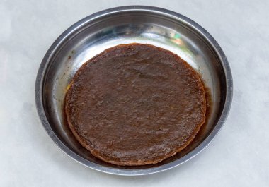 Lezzetli Amsotto, çelik tabakta geleneksel bir Bengali mango barı (Aam Papad). Güneşte kurutulmuş mango derisi.