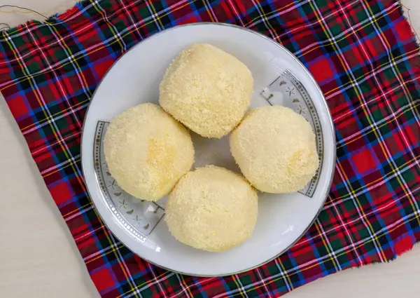 Lezzetli Bengali Kachagolla tatlılarının seramik tabakta üst görüntüsü. Yumuşak, süngerimsi dokusu ve ince tatlılığıyla ünlüdür..