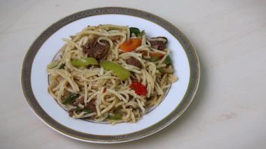 Capsicum, Domates ve Chili 'li Lezzetli Biftek Eriştesi' nin yakın çekimi. Tahta Yüzeyde İştah Açıcı Tabak.