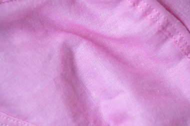 Gül pembesi pamuk kumaş örtüsü yakın plan. Yumuşak giysi dokusu, zengin, lüks katlar ve pürüzsüz örtülerle donatılmış. Tekstil, moda ve soyut tasarım için ideal.
