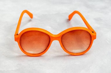 Çocuklar için canlı turuncu bir plastik göz giysisi oyuncağı. Bu yaşlı çocuğun aksesuarı nostalji ve oyunculuğu çağrıştırıyor..