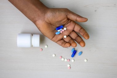 Bir sürü tablet ve hapla yakın plan kadın eli yere saçılmış bir şişenin yanında. Bunalımlı kadın. Uyuşturucu bağımlılığına, tıbbi istismara, uyuşturucuya ve bağımlılığa odaklan. Üst görünüm.