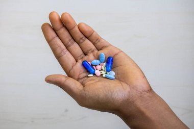 Çeşitli ilaç ve kapsüllerle kadın eli depresyonu, aşırı dozu ve uyuşturucu bağımlılığını temsil eden güçlü bir görüntü. Akıl sağlığı, uyuşturucu ve anti-psikotik kavramlar için ideal..