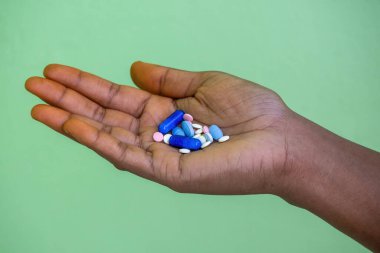 Çeşitli hap ve kapsülleri tutan bir kadının yakın çekimi. Depresyon, aşırı doz, intihar, uyuşturucu bağımlılığı, uyuşturucu bağımlılığı ve psikoz gibi akıl sağlığı sorunları.