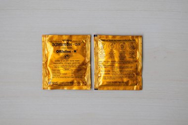 Ahşap arka planda SMC Orsaline Sachets. Ön ve arka manzara. Bangladeş 'in ishal ve susuzluk yönetimi için en iyi seçeneği. Ülke çapında güvenilir ORS markası.