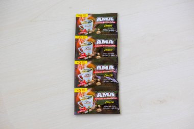 Light Wooden Surface 'de sergilenen dört AMA Otantik Brezilya Soluble Kahve Tozu Mini Paketi. Lezzetli Anlık Kahve Günlük Anlar İçin.