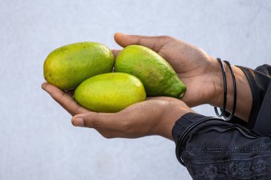Yakın plan kadın eli taze yeşil limon tutuyor. Sağlıklı narenciye, limon. Sağlıklı yaşam ve sağlığın doğal C vitamini kaynağı..