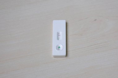 Tahta üzerinde negatif yumurtlama testi kiti yakın plan. Luteinizing Hormone (LH) için bir satır LH dalgalanması göstermiyor.