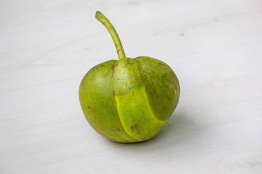 Taze Chalta (Dillenia indica), açık ahşap bir yüzey üzerinde fil elması olarak da bilinir. Bu tropikal Hint meyvesi eşsiz mutfak kullanımı için harikadır..