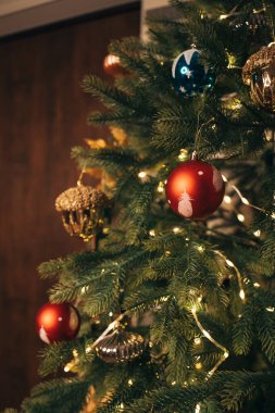 Çelenk ve tuhaf süslerle süslenmiş neşeli bir Noel Ağacı.