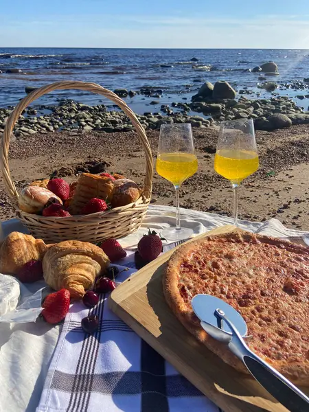delicious pizza with wine, grapes and wine on the beach coast