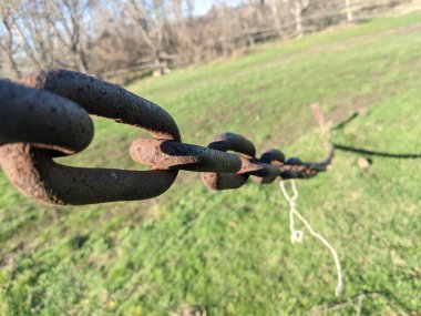 Çimlerin üzerinde paslı zincir ve zincir