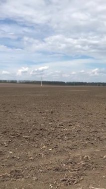 Önceden ekilmiş bir tarlanın bahar manzaraları. Toprak yeni bir mevsim için hazırlanıyor. Bulutlu gökyüzü üzerinde süzülüyor, boşluğu yağmur ve bereket beklentisiyle dolduruyor.