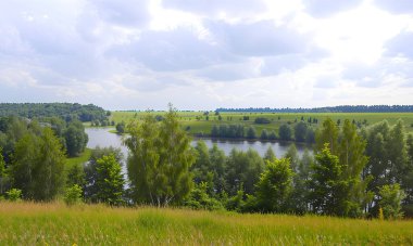 Toprak yol, uçsuz bucaksız tarlalarda bir kurdele gibi esiyor. İzleri, zamanın izleri gibi, ufka gidiyor. Bir tarafta uzun yeşil çimenler, diğer tarafta yeşil ağaçlar vardır.