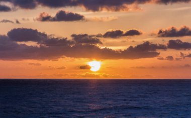 Okyanusun üzerinde bulutlarla gün batımı