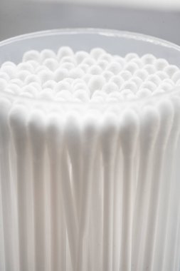 Beyaz pamuklu kulak temizleme tomurcukları beyaz arka planda konteynırda güzelce yerleştirilmiş.