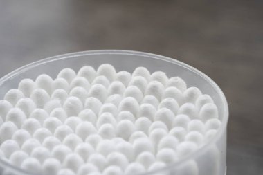 Beyaz pamuklu kulak temizleme tomurcukları beyaz arka planda konteynırda güzelce yerleştirilmiş.