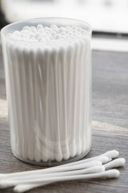 Beyaz pamuklu kulak temizleme tomurcukları beyaz arka planda konteynırda güzelce yerleştirilmiş.