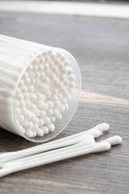 Beyaz pamuklu kulak temizleme tomurcukları beyaz arka planda konteynırda güzelce yerleştirilmiş.