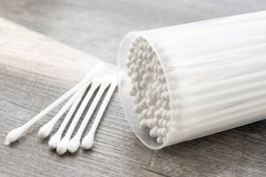 Beyaz pamuklu kulak temizleme tomurcukları beyaz arka planda konteynırda güzelce yerleştirilmiş.