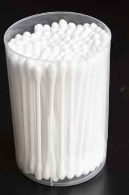 Beyaz pamuk kulak temizleme tomurcuklarının makro görünümü siyah arkaplanda güzelce konteynırda düzenlenmiştir