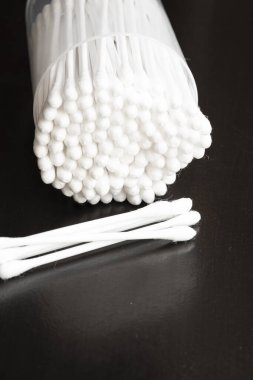 Beyaz pamuk kulak temizleme tomurcuklarının makro görünümü siyah arkaplanda güzelce konteynırda düzenlenmiştir