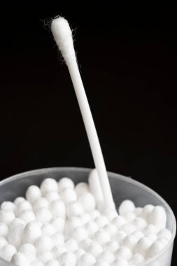Beyaz pamuk kulak temizleme tomurcuklarının makro görünümü siyah arkaplanda güzelce konteynırda düzenlenmiştir