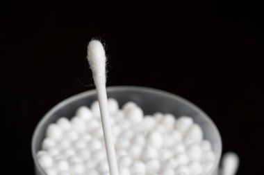 Beyaz pamuk kulak temizleme tomurcuklarının makro görünümü siyah arkaplanda güzelce konteynırda düzenlenmiştir