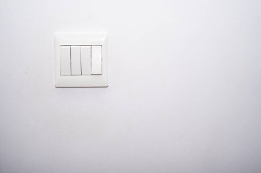 Bir odadaki beyaz renkli duvara yüklenmiş ışık kontrol düğmesi beyaz rengi