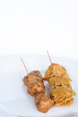 Çin yemeğinin yakın çekim görüntüsü. Hınzırca kızartılmış, beyaz renkli tabakta, üzerinde çubuk var.