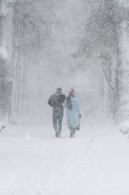 Couple walking in snowy cityscape, winter's embrace