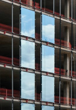 İnşaat halindeki çok katlı bina, iskele ve mavi gökyüzü.