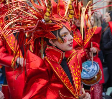 Karnavalda parlak kırmızı kostümlü bir kız..