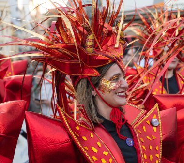 Karnavalda parlak kırmızı kostümlü bir kadın..