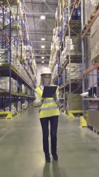 Wanita Pekerja Gudang Berjalan Melalui Baris Rak Penyimpanan Dengan Barang — Stok Video