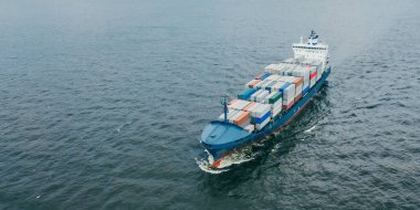 Denizde konteynır taşıyan mavi kargo gemisinin hava görüntüsü.