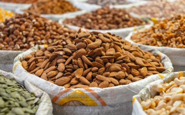 Piyasadaki diğer fındık ve tohumlar arasında bir poşet badem.